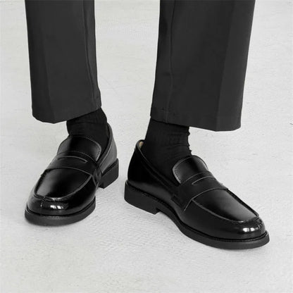Classic black slip-on Derby leather shoes for men and women on a plain background