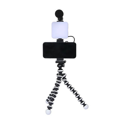 Square LED camera flash with universal hot shoe mount and rotatable head, shown with optional octopus stand tripod.