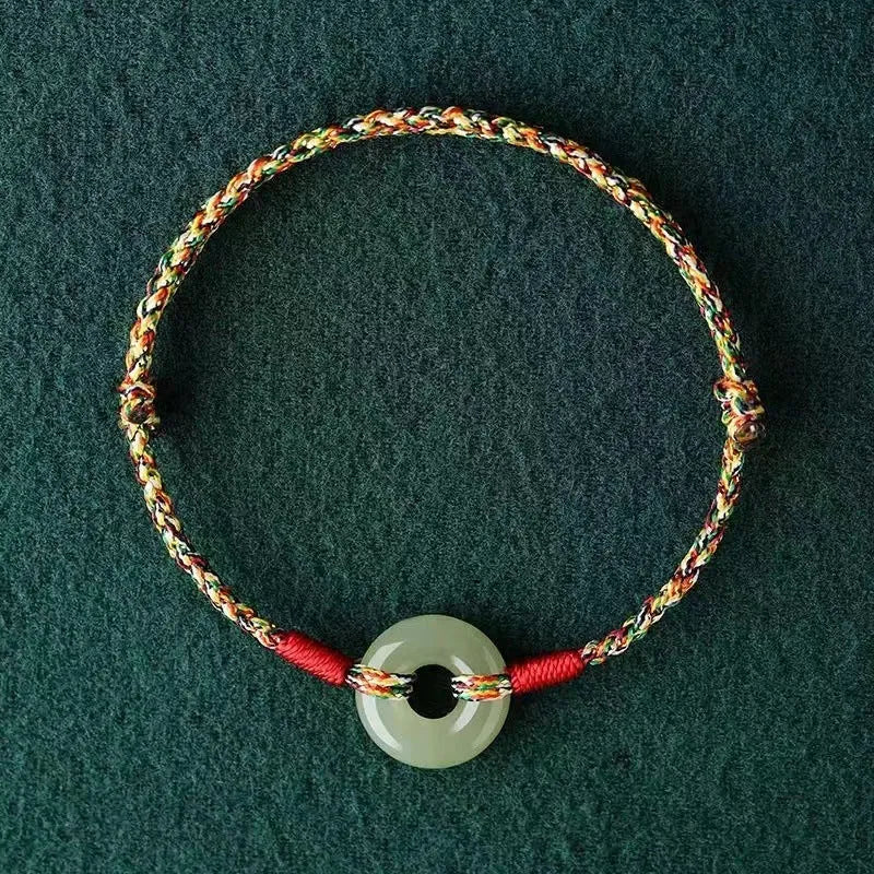 Colourful woven rope bracelet with silver peace buckle fastening on wrist