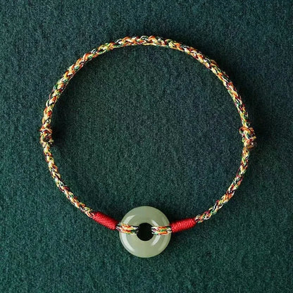 Colourful woven rope bracelet with silver peace buckle fastening on wrist