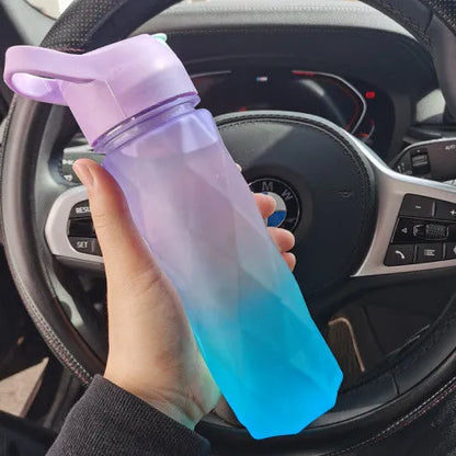 White spray water bottle with black leakproof lid and handle strap on a table