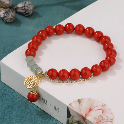 Retro women's bracelet with red cinnabar fu charm, jade bead, and tassel.