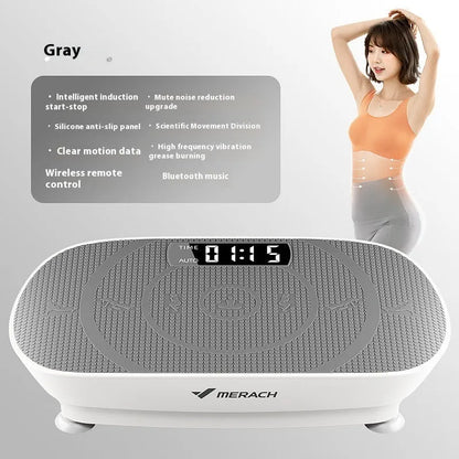 Grey portable vibration plate on a wooden floor, showing its slim 16cm profile and textured platform surface.