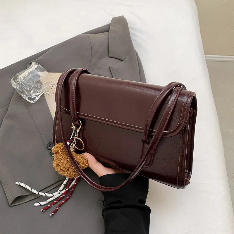 Brown women's square shoulder bag with double straps and pendant accessory