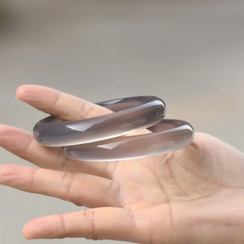 Dark gray Brazilian agate women's bracelet with circle and ring design on a wrist.