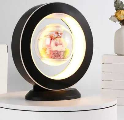 Pink rose eternal flower floating in magnetic levitation LED night light with triangular base and touch control