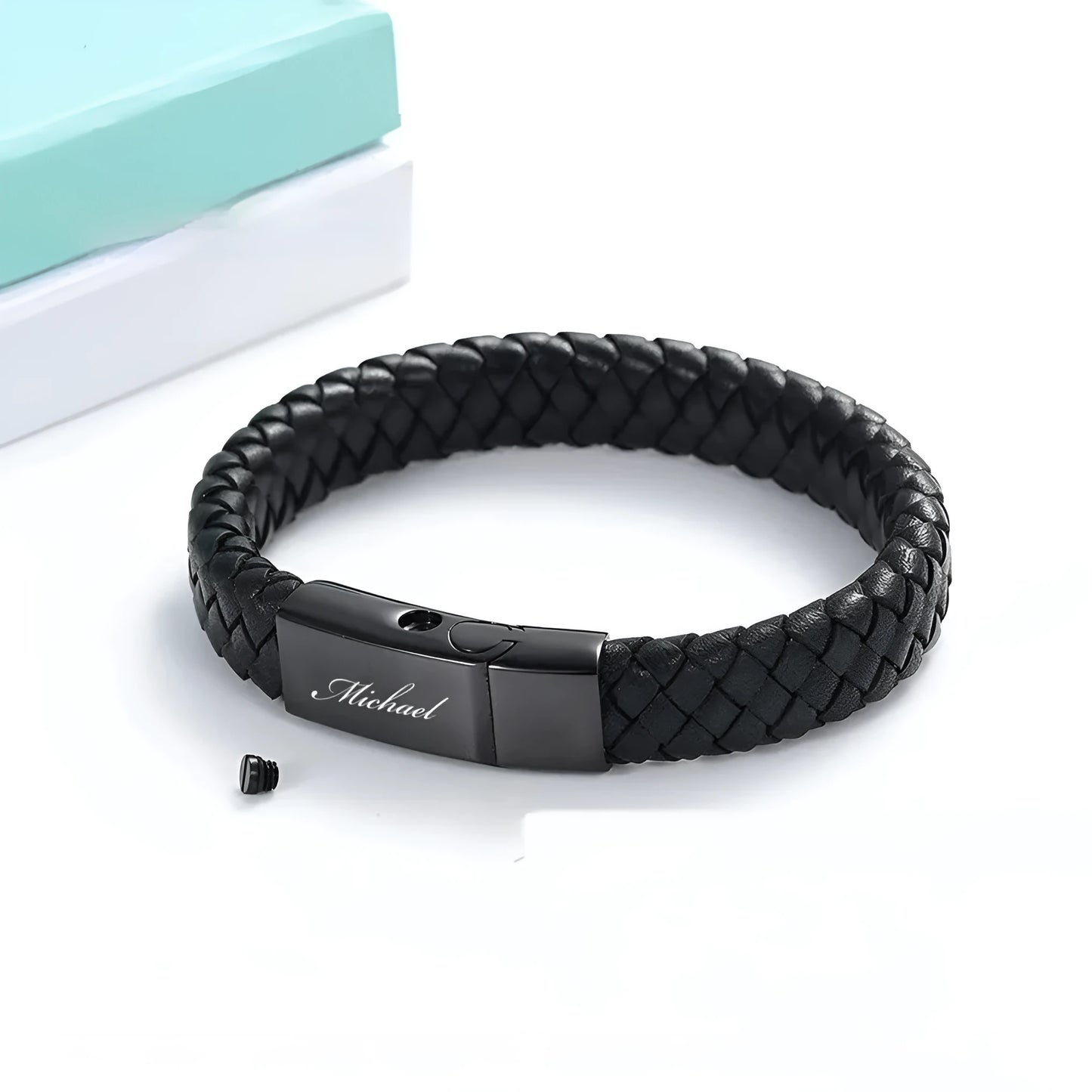 Black leather and stainless steel cinerary bracelet with personalised English letters, presented in a gift box.