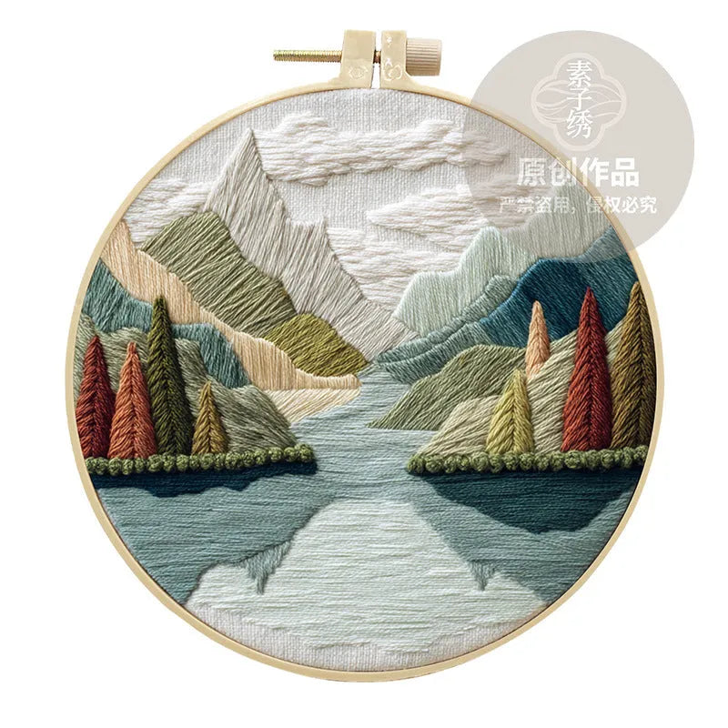 Complete DIY embroidery kit with 15cm bamboo frame, pre-printed landscape fabric, threads, and needles laid out.