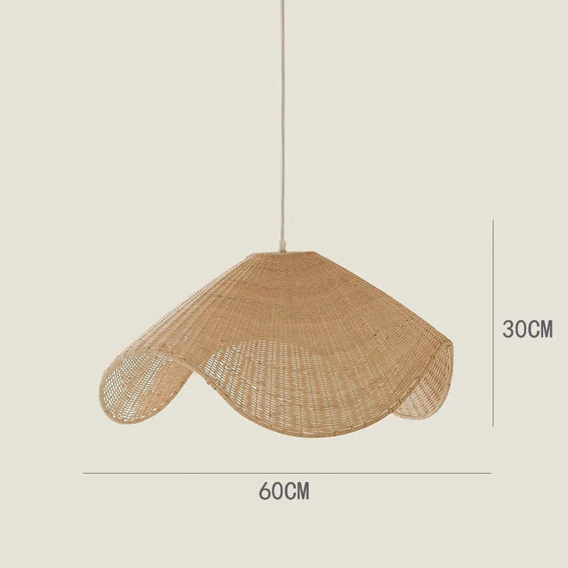 Handmade woven rattan and willow chandelier with warm LED light in a rustic setting.