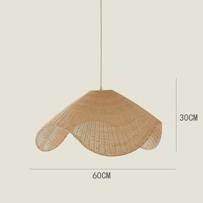 Handmade woven rattan and willow chandelier with warm LED light in a rustic setting.