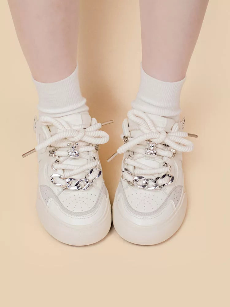 Women's white low-top sneakers with rubber sole and lace-up closure