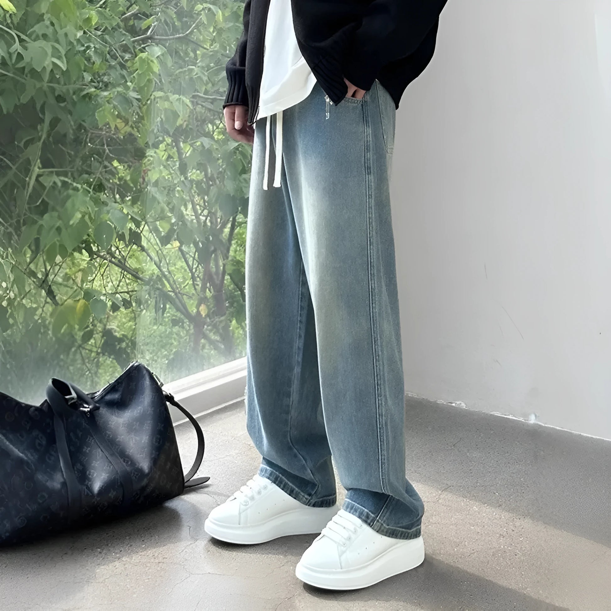 Men's blue straight-leg denim trousers with drawstring waist shown on hanger