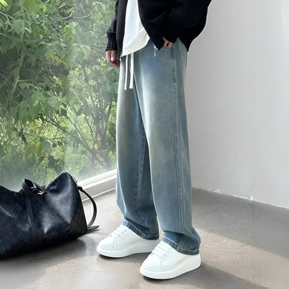 Men's blue straight-leg denim trousers with drawstring waist shown on hanger