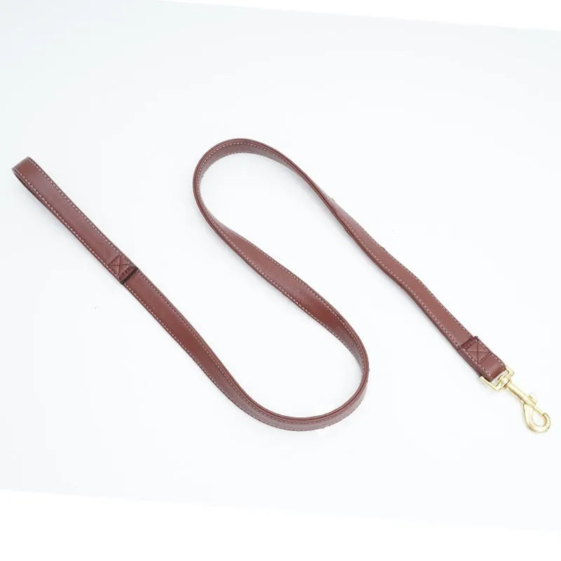 Black PU leather dog lead with brass buckle and padded handle, laid out to show length.