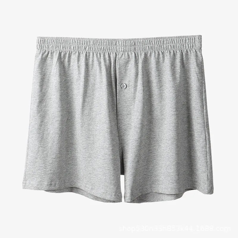 Men's light grey cotton boxer shorts with a loose fit and high waist on a plain background.