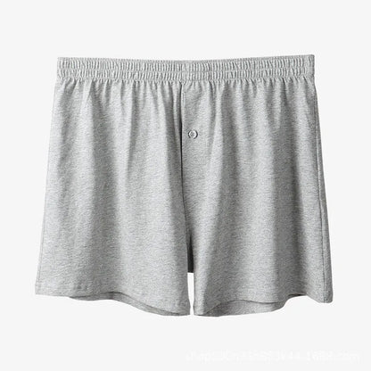 Men's light grey cotton boxer shorts with a loose fit and high waist on a plain background.