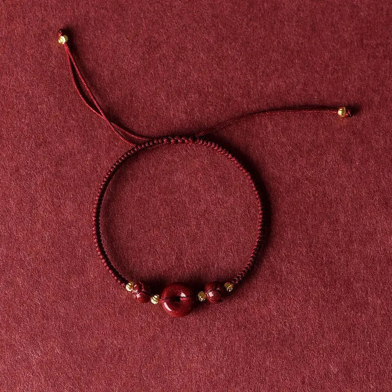 Cinnabar heart-shaped bracelet with safety buckle closure and adjustable coloured rope in traditional Chinese design