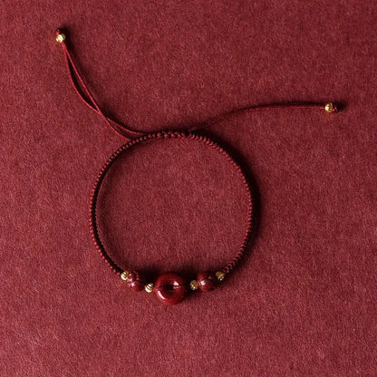 Cinnabar heart-shaped bracelet with safety buckle closure and adjustable coloured rope in traditional Chinese design