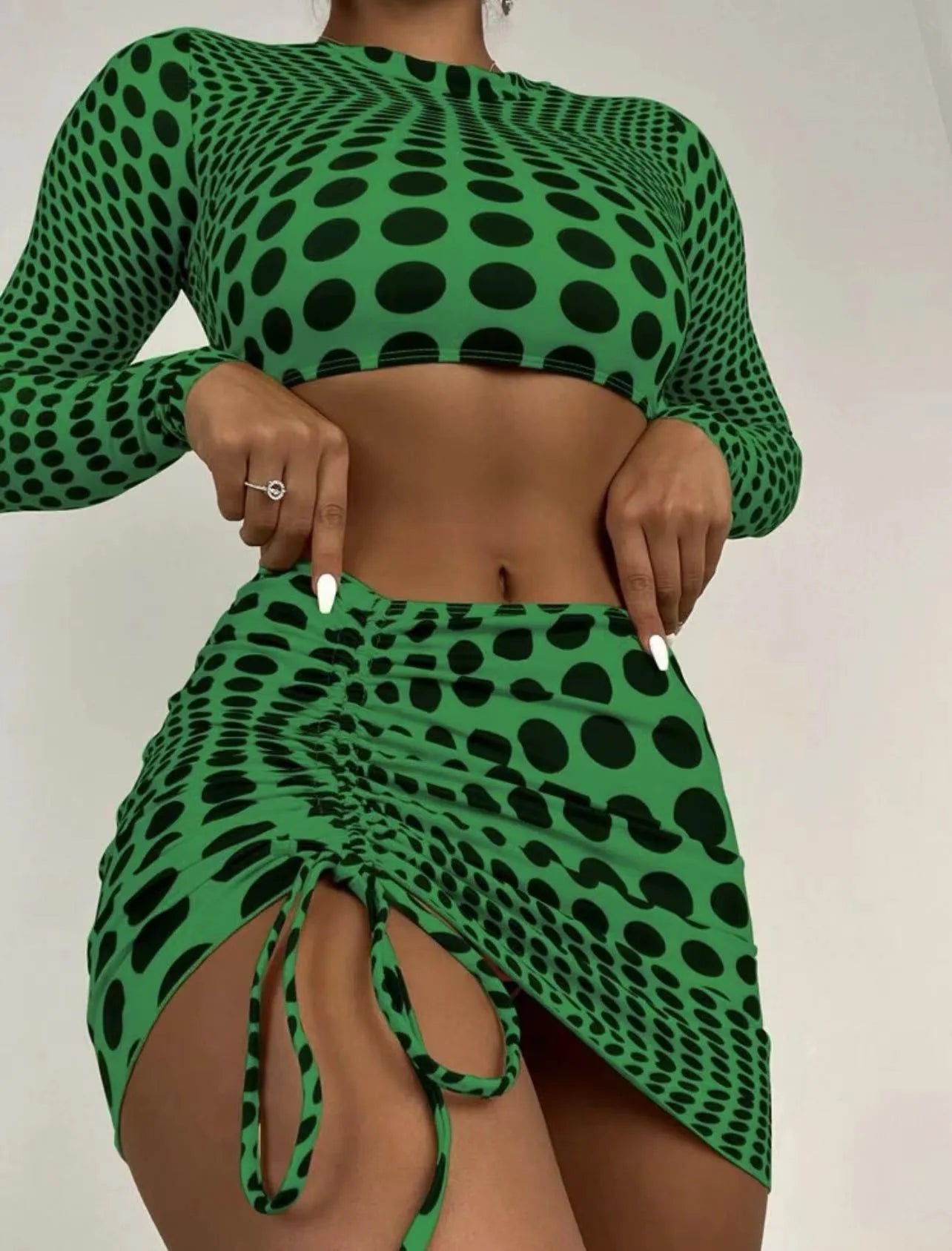 Women's green polka dot three-piece swimsuit set showing top, skirt, and bra