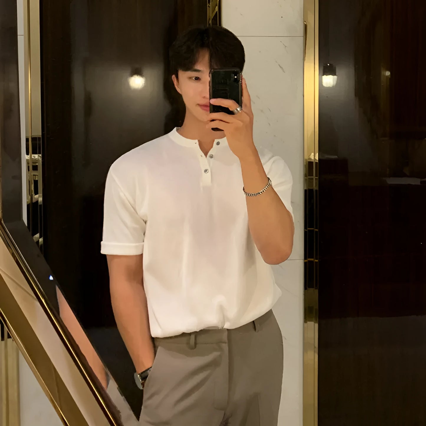 Man wearing a black slim-fit short-sleeved ice silk knit pullover shirt.
