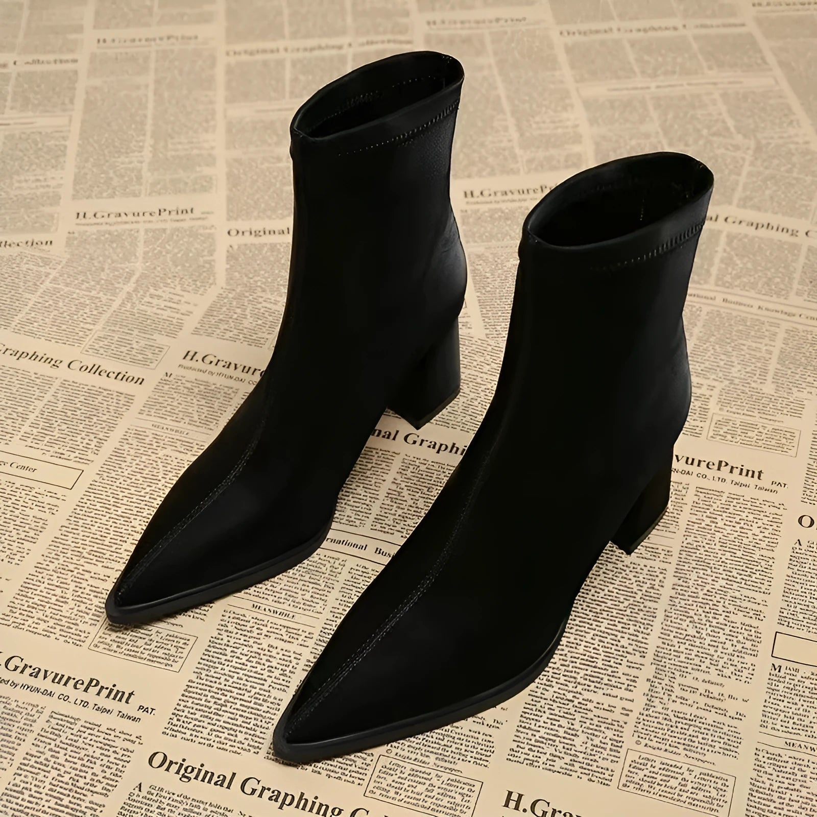 Women's khaki stretch suedette pointed toe ankle boots with a mid block heel on a white background.