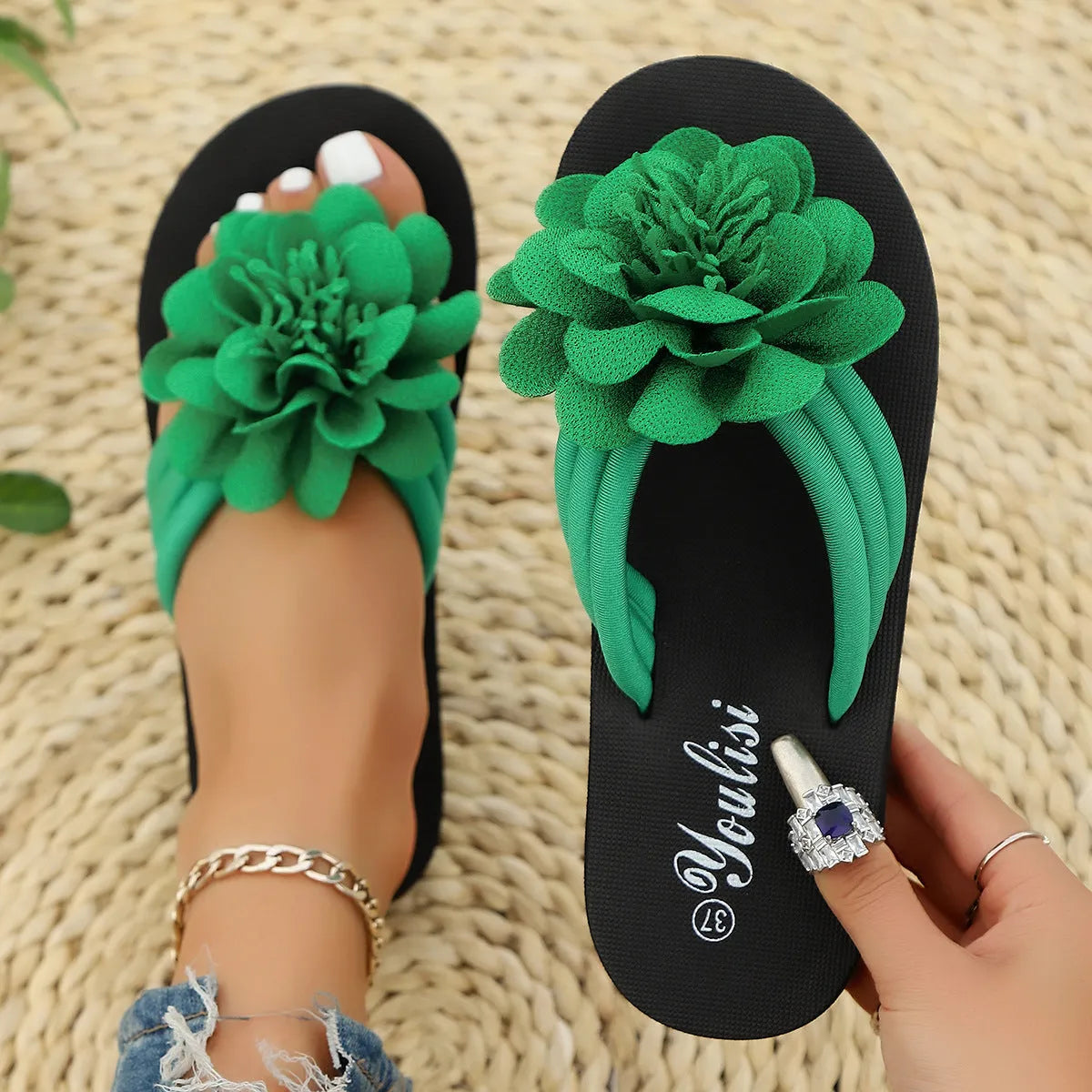Solid-colour flower flip flops with a decorative floral detail on a viscose upper and EVA sole.