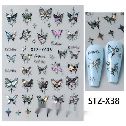 Assortment of black and silver nail sticker designs including cartoon and French tip patterns on a plastic sheet.