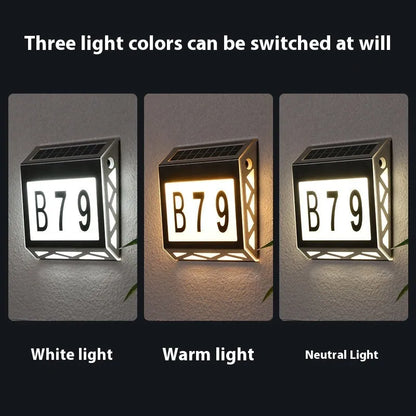 Black solar doorplate light with LED illumination showing house numbers