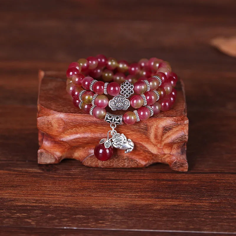 Handmade bracelet with green and pink watermelon crystal beads tied with Chinese knots.