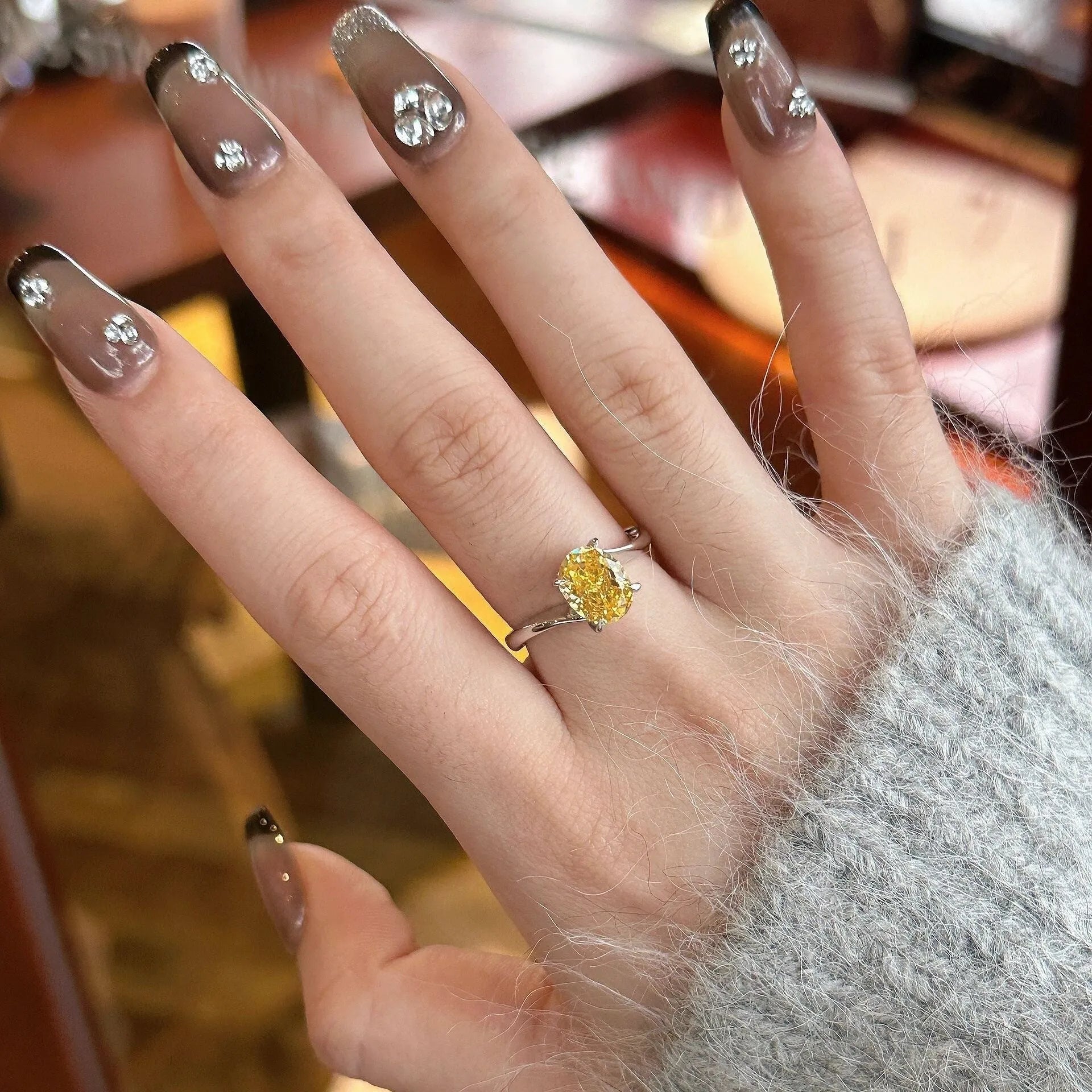Women's yellow rock sugar crystal copper fashion ring on a hand.
