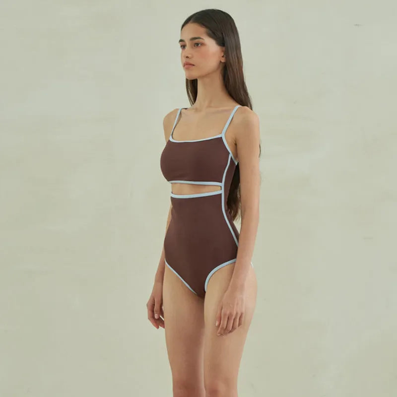 Brown women's one-piece swimsuit with triangle front and adjustable tie-back straps on a neutral background.