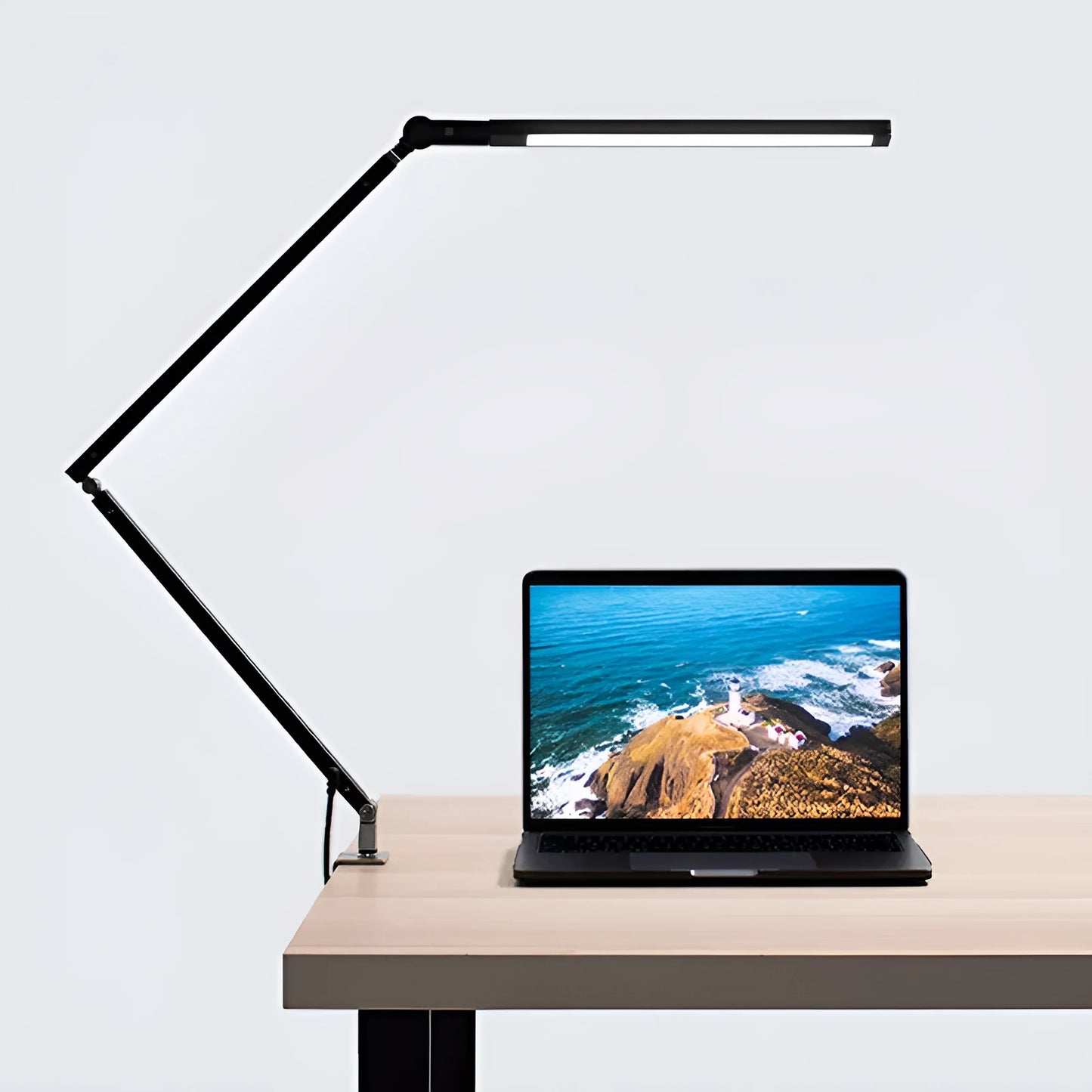 Adjustable aluminium desk lamp with remote control, shown in black with a clip attached to a desk edge.