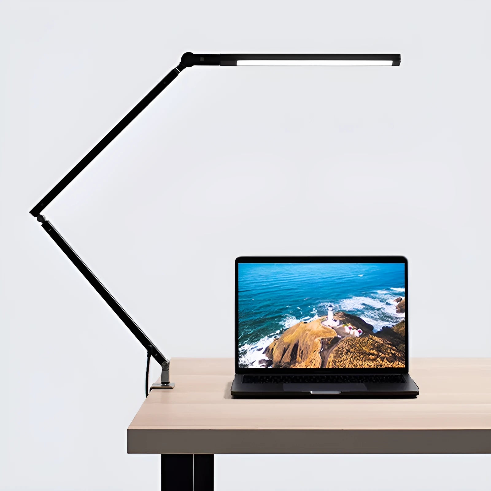 Adjustable aluminium desk lamp with remote control, shown in black with a clip attached to a desk edge.