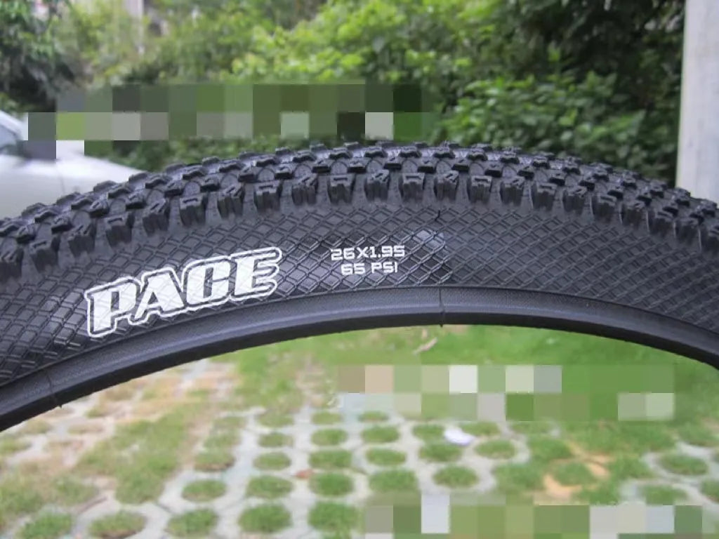Mountain bike tyre with black tread and sidewall, showing size options like 26x1.95 and 29x2.1 inches for off-road cycling.