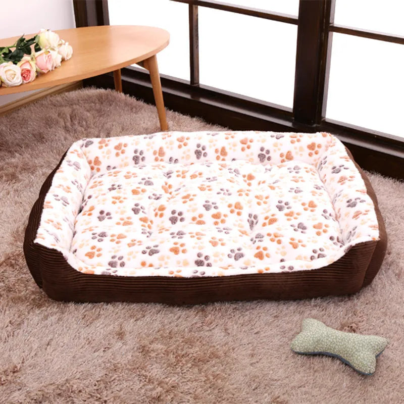 Beige plush pet bed for small dogs with a removable cover and non-slip base, shown in a home setting.