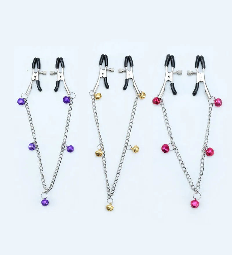 Red and purple nipple clamps with small bells and feather decorations for adult sensory play.