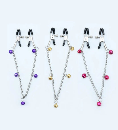 Red and purple nipple clamps with small bells and feather decorations for adult sensory play.
