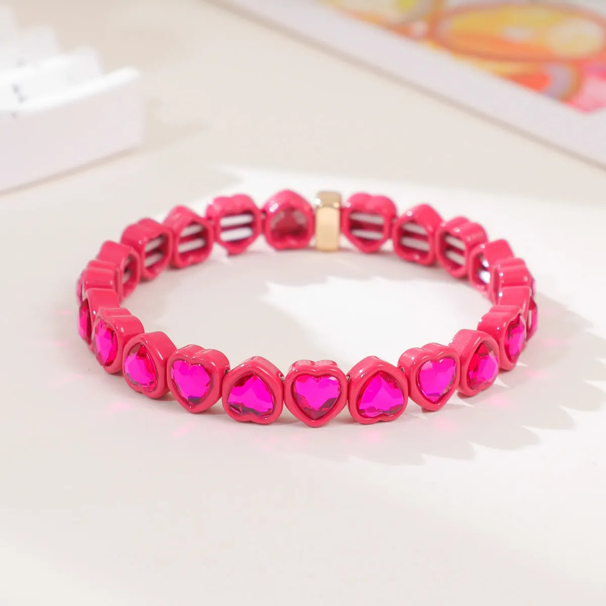 Colourful enamel heart shape on a silver-toned alloy stretch bracelet.