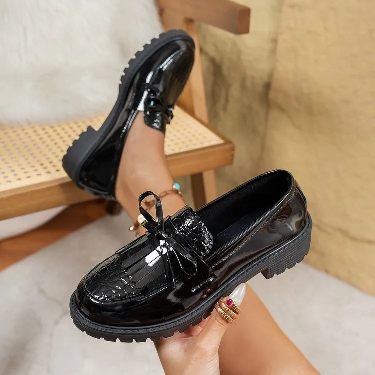 Women's brown artificial PU loafers with a bow detail on the pointed toe, shown on a size label.