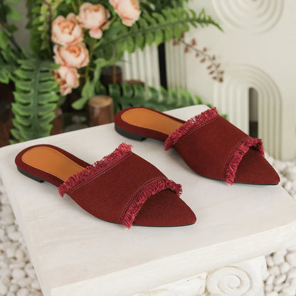 Women's denim flat slippers with tassel detail in apricot colour, showing leather lining.