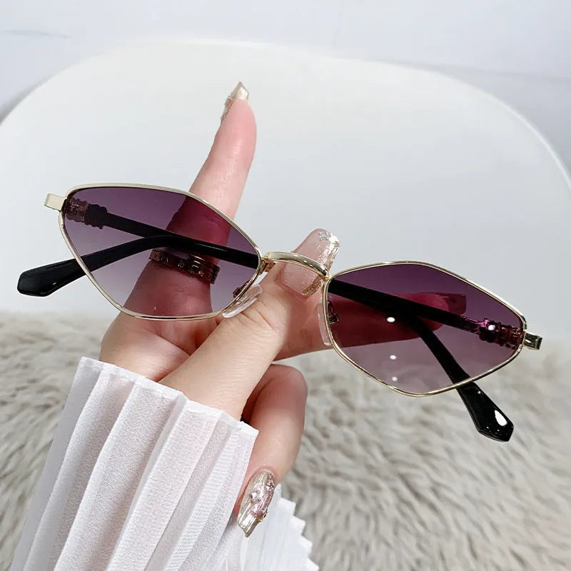 Gold metal frame rhombus-shaped cat eye sunglasses on a neutral background.