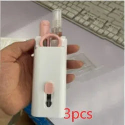 White electronics cleaning kit with a cleaning pen, spray bottle, brush, and keycap puller on a table