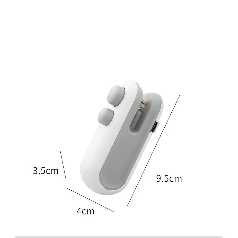 Handheld white portable heat sealer with USB Type-C port and magnetic back on a metal surface.
