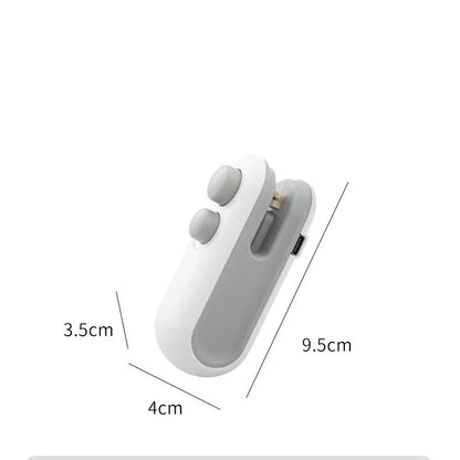 Handheld white portable heat sealer with USB Type-C port and magnetic back on a metal surface.