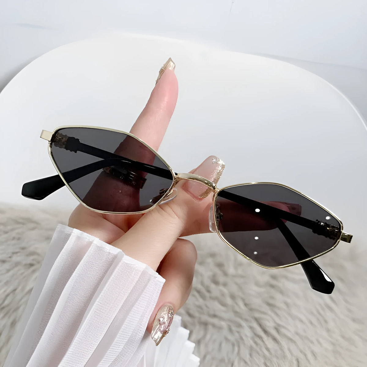 Gold metal frame rhombus-shaped cat eye sunglasses on a neutral background.