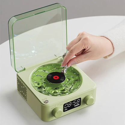 Retro-style turntable Bluetooth speaker with glowing RGB light projection on a wooden surface.