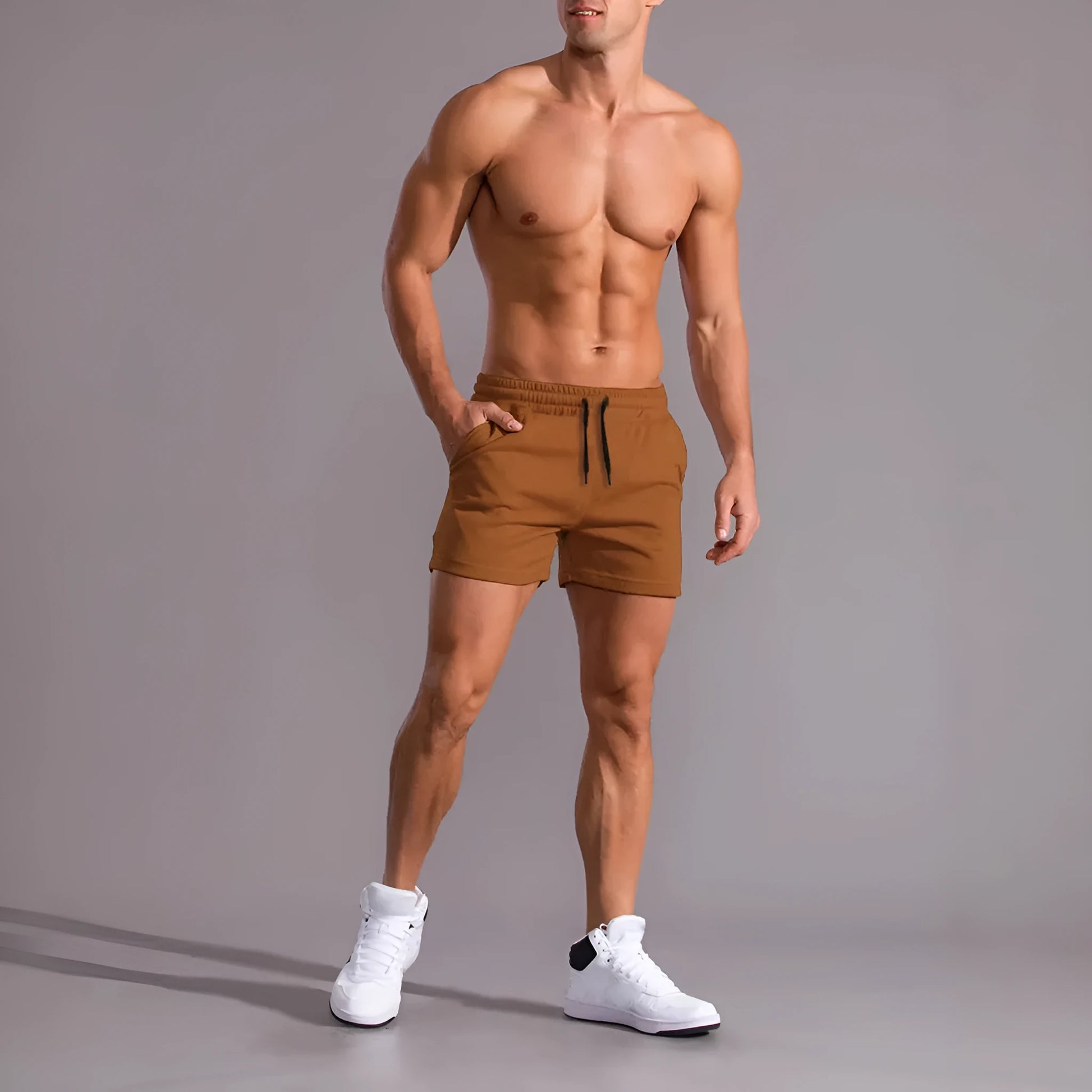 Three pairs of men's solid colour loose-fit drawstring shorts in black, khaki, and light brown laid flat.