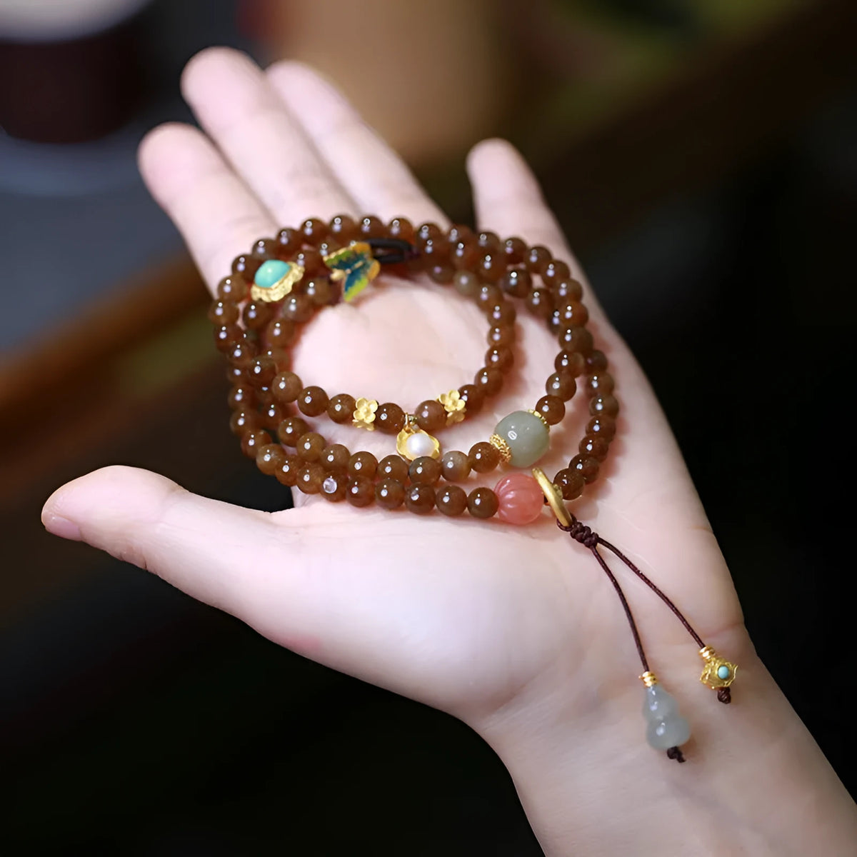 Brown jade women's bracelet with silver butterfly charm and three-ring design.