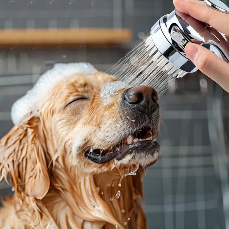 Silver dog shower attachment with integrated silicone comb and rubber grip handles.