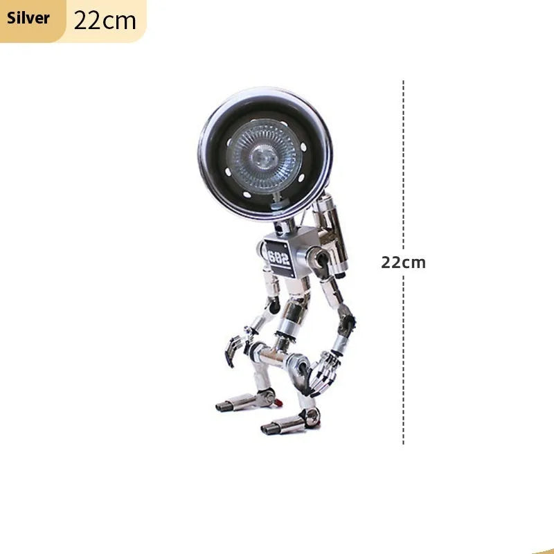 Silver copper robot-shaped decorative desk lamp with custom graphic option on a wooden shelf.